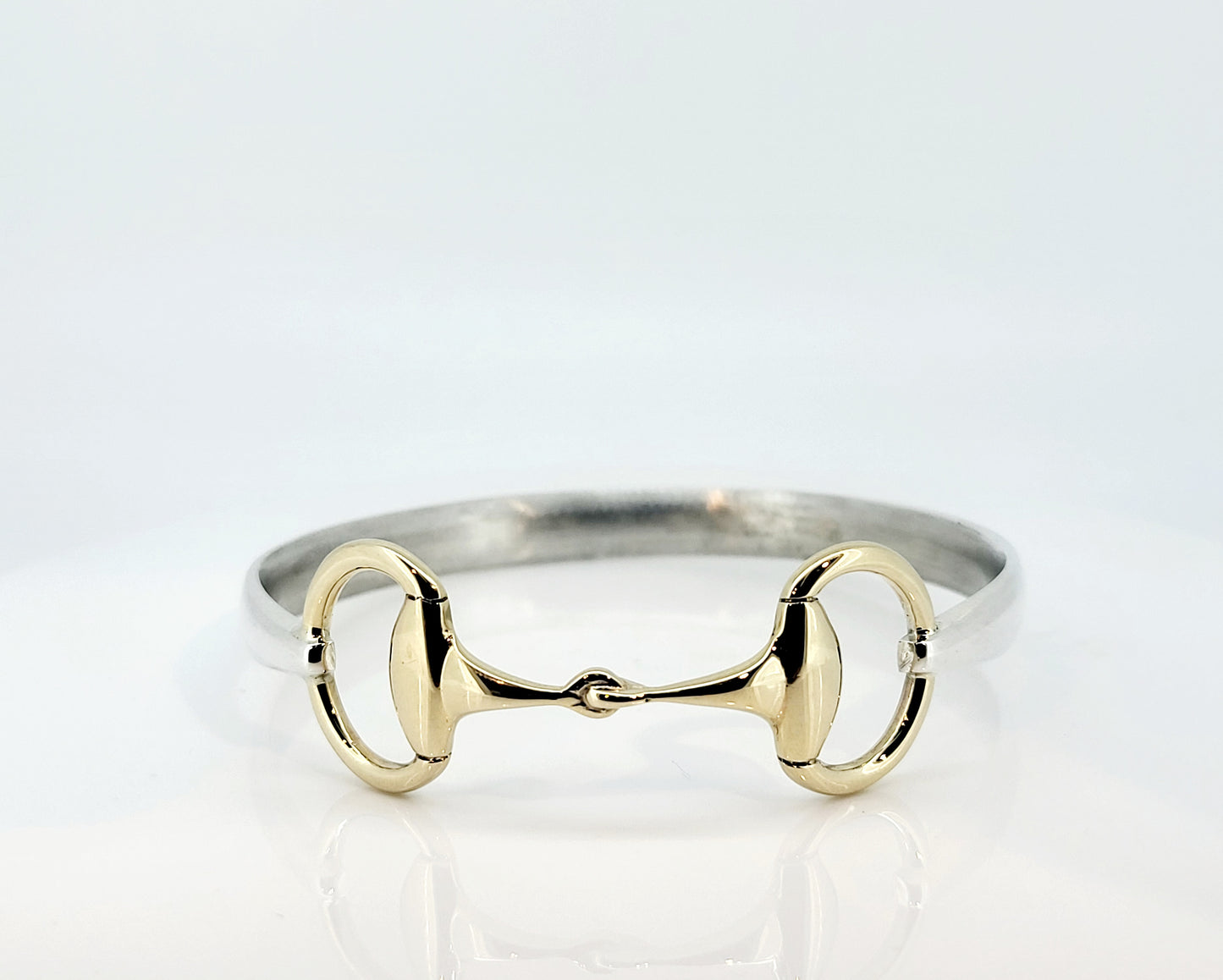 A two tone snaffle bangle. The snaffle is a solid 9ct yellow gold, and the band in sterling silver.