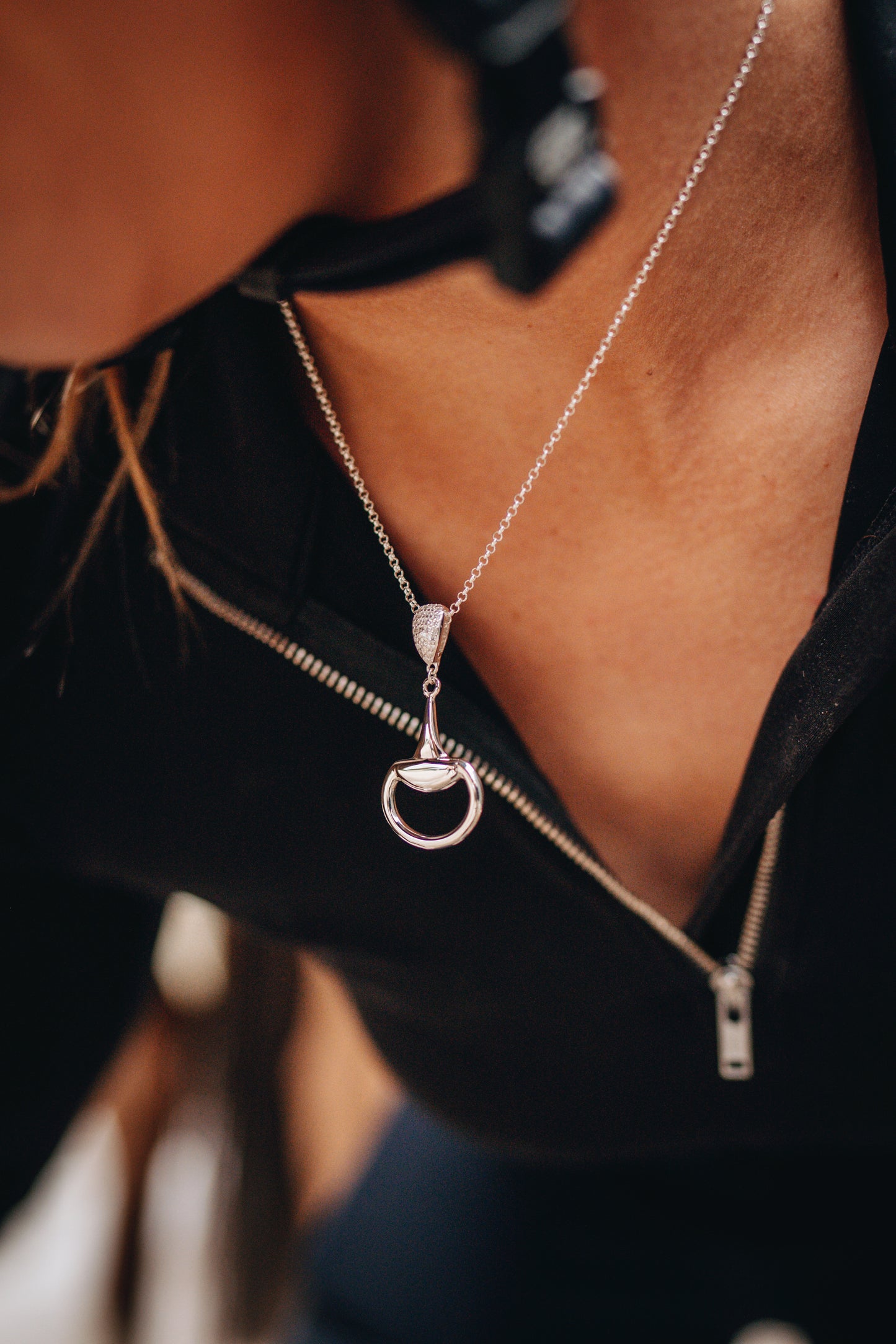An equestrian horse rider ready to mount wearing a sterling silver Bling Half Snaffle Pendant.