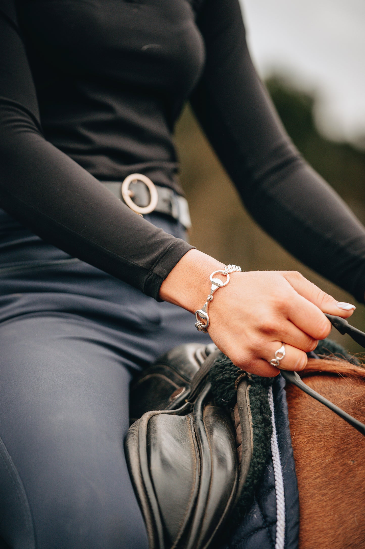 Rider wearing the Crawford Hill Curb Chain & Snaffle Bracelet. Complemented by a sterling silver Snaffle Ring