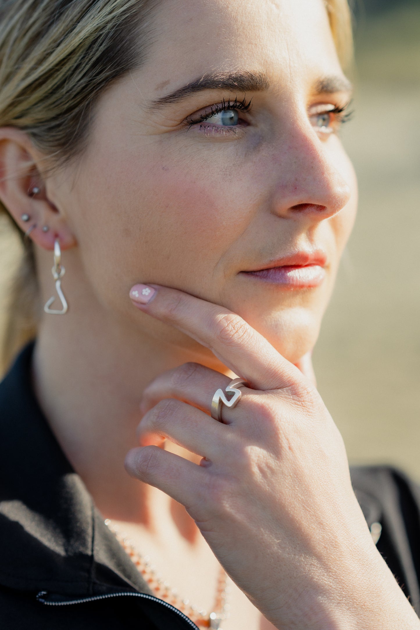 Equestrian deep in thought. Wearing the Crawford Hill Jump Ring. In the background, you can see her wearing the sterling silver Jump Stirrup Earrings.