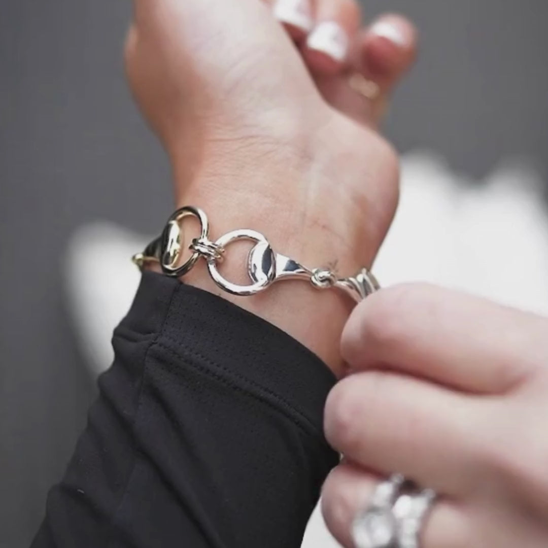 Equestrian wearing a three horse bit snaffle bracelet.
