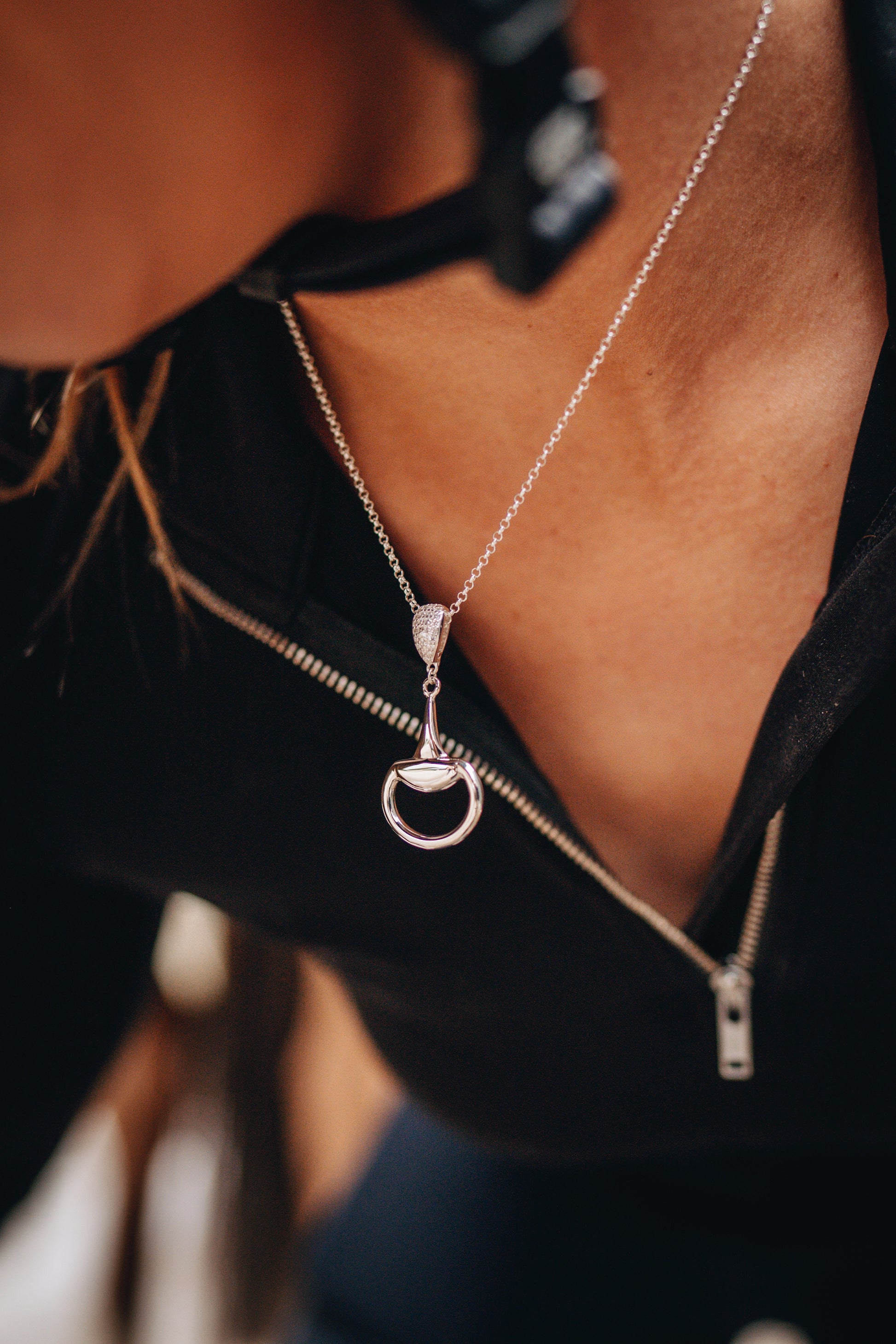 An equestrian horse rider ready to mount wearing a sterling silver Bling Half Snaffle Pendant. 