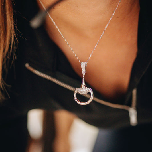 Equestrian horse rider wearing a diamond set half snaffle pendant.